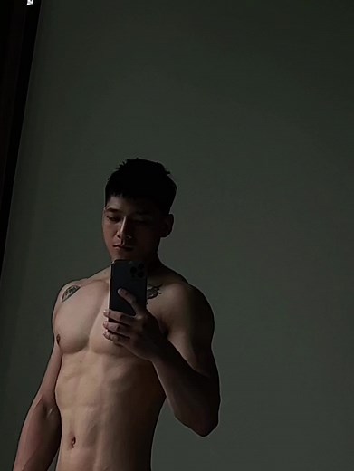 Muscular Male Taking Selfie in Dimly Lit Room
