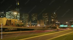 Loop of Traffic passes along a city freeway at night.