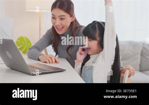 Woman and girl celebrating while using laptop Stock Video Footage - Alamy