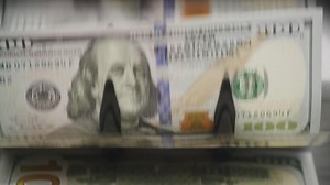Close-up of dollar bills in money counter