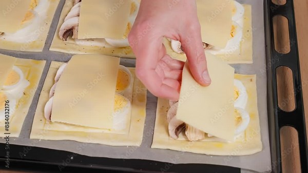 Close-up of a mini pizza with mushrooms and cheese, the chef lays out the slices of cheese. Mini pizza, snack, top view, macro
