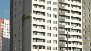 Working in a construction cradle rubs plaster