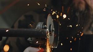 Sparks flying off of an angle grinder cutting a piece of metal  - Free Stock Video