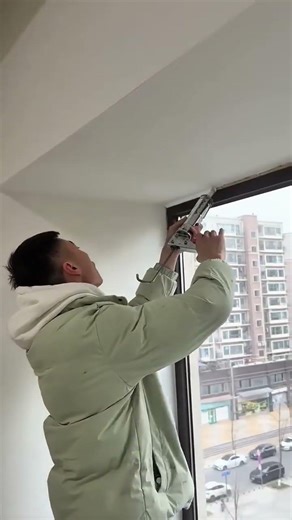 applying white sealant to the window frame for —professional and elegant building maintenance work.