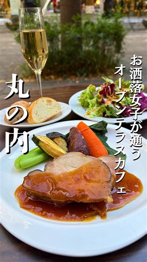 maki | 銀座グルメ・カフェ on Instagram: "丸の内イルミネーションが一望できる大人気カフェ 保存＆フォローはこちら💁‍♀️ @makimaki0503 **行列ができる丸の内の人気店でご褒美ランチを✨ 丸の内仲通りに面した、開放感たっぷりのスタイリッシュレストラン。 店内は木の質感とアートが調和した温かい空間で、平日でも女性客を中心に常に賑わう人気店。テラス席もあり、丸の内OL・デート・接待まで幅広く支持されているお店です。 この日はランチコースを注文。 スパークリングワインで乾杯してからいただく サラダは彩り鮮やかでボリュームたっぷり。 メインの豚肩肉のロースト りんごのガストリックソース は、香ばしく焼かれたお肉の旨みと、りんごの甘酸っぱさが重たくなりすぎず上品にマッチ。ソースの深みがあって、スパークリングとの相性も抜群でした。 パンもおかわり自由なのでソースと合わせても最高。 食後の エンゼルフードケーキ（シフォンのようにふわふわ） は、軽やかな口どけの中にバニラとキャラメルの香りがふんわり広がるデザートで、ランチの締めにぴったりの優しい甘さでした。 丸の内