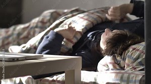woman wakes up early in the morning in bed and looks at the phone