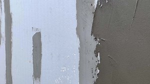 Download Hand with a putty knife, apply the putty to the wall. Process of applying a layer of putty. A man plasters the facade after insulating the building with polystyrene. Concept of construction. for free