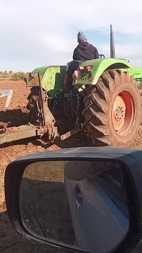 Operating a Green Tractor in Expansive Fields