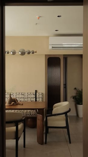 Nika Design Studio on Instagram: "From the dining space to the kitchen, warm finishes, soft tones, and seamless storage create an environment that feels balanced, functional, and inviting. Where everyday moments flow with ease.🍃 Save if you love warm, textured spaces. @hgala05 × @nika.designstudio Designed by : @nika.designstudio Design team: @shreya__2402 @durvaraval02 Videographed by: @wabi_sabi.studios Photographed by: @wabi_sabi.studios Styled by: @mish1193 Main Flooring by: @nexionstudiomu