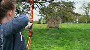 Archery: HD footage of girl shooting a bow and arrow at an archery range.
