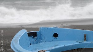 stormy sea pushed by heavy rain and wind forms big waves that break on the beach