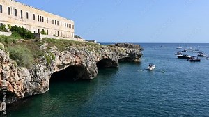Santa maria di Leuca, Puglia, Italy. Amazing pan footage of the natural caves on the coast: bathers swim in the crystal clear water to see them up close.