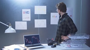 Man Analyzing Data and Charts in Office
