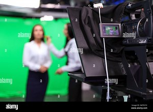 Presenter and makeup artist working in studio, focus on video camera Stock Photo - Alamy