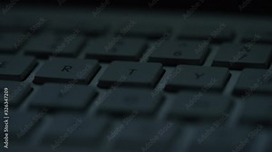 Camera pans across the keys of a keyboard in the dark