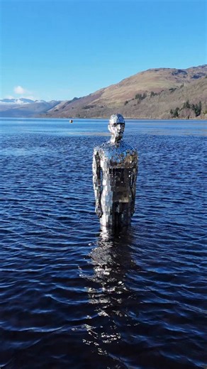 The Mirror Man of Loch Earn officially titled “Still,” is a striking, life-sized sculpture created by artist Rob Mulholland. Made from mirrored stainless steel, the figure stands partially submerged in the loch, reflecting the surrounding landscape and blending seamlessly into the water and sky. #robmulhollandsculptures #visitscotland #edinburghblackcabtours #scotland #travel | Edinburgh Black Cab Tours