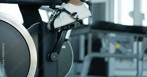 Selective focus, Legs of young female spinning bike machine in gym for workout, Young woman exercise with spin on air bike simulator for cardiology health Stock Video