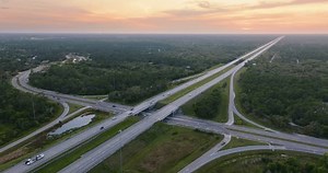 Wide multilane highway crossroads in USA with fast driving cars. Above view of Florida transportation infrastructure