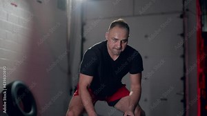 Assertive man doing exercises with battle rope, ruthlessly effective workout.