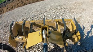 Box scrapper leveling on a new graveled driveway, tractor making large loop; concepts of blue collar work, hydraulics, new construction and country life