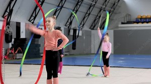Competition preparation. Little girl, child, rhythmic gymnast training indoor, doing exercise with ribbon. Concept of sportive lifestyle, childhood, education, health, professional sport, championship