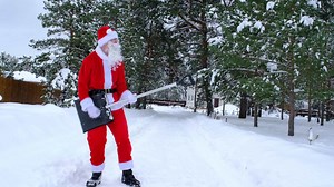 Santa Claus dancing funny with a shovel and plays like a guitar and cleans snow with shovel in winter outdoors after a snowfall. Humor for Christmas and New Year