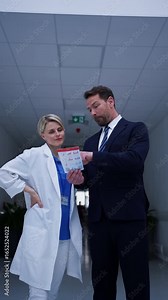 Pharmaceutical sales representative introducing new medication to female doctor.