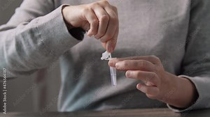 medicine, quarantine and pandemic concept - woman taking sample from her nose with swab and making self testing nasal coronavirus test at home