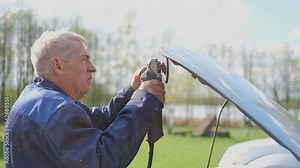 Car body shop. Repair man processes the welding seam using an angle grinder on replaced car part. Professional Body master grind old paint and rust. Rusty damage. Rusting car. Hands with tool close-up