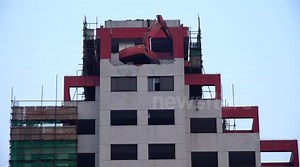 Digger balanced in risky position on demolition site in Shanghai