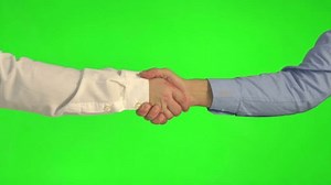 Handshake on a green background in 4k slow motion 60fps