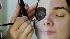 Make-up artist is making blonde woman up as dead bride for halloween party. 4K