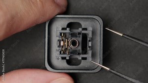 Disassembling Mechanical Keyboard Switch With Pointed Tweezers. closeup, overhead