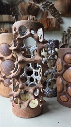 Vanessa Veck on Instagram: "With certain ideas I like to revisit them with slightly different iterations, (idk, does everyone do that?) For this candle holder/space framer/empty vessel I opted to make a slimmer silhouette and put crackle glaze on the inside (which was clumsy-making in the glaze room.) Having a pattern on the inside reminds me of a lined jacket for some reason. I like it tho! And I think it fits in well with it's siblings, don't you? I still think about Kiki & Boba #ceramicart #c