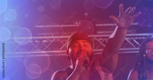 Lens flare clearing revealing lead singer drawing hand mic closer and singing music engaging crowd