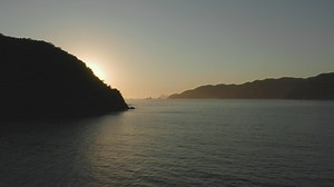 Sunset seen at sea from a coast, aerial shot - Free Stock Video