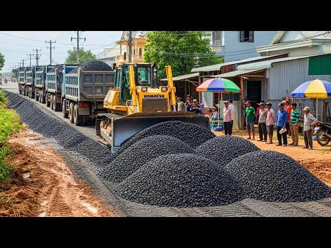 Expert Opitmizing Road Base Gravel Laid by Skillful Bulldozer in City as Dump Truck Feeding Gravel
