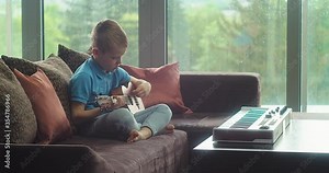 Child playing on guitar at home. Dad teaches boy to play guitar. Music hobby, Create, learning own songs. 4K video.