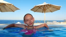 Fille se relaxant dans la piscine à débordement profitant des...