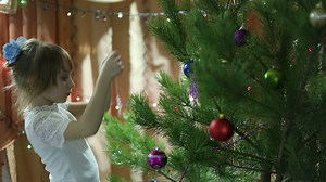 Child decorating a Christmas tree with a snowflake - Free Stock Video