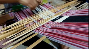 Close up of Timorese women skilfully working on making a traditional cultural colourful tais woven fabric on a loom in Timor Leste, South East Asia