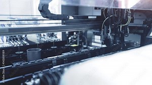 Automated Electronic circuit board production. Machine Produces Printed digital board, contract manufacturing - detail view of microchip production line. High-tech. Full HD resolution. Blue toning