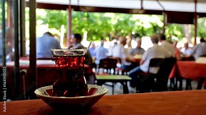 The hot black tea in the popular tea house in old town, famous among local seniors, relaxing on the summer terrace and playing tile-based game Okey, Antalya, Turkey.