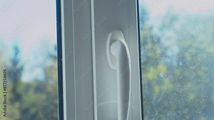 Repair and adjustment of a plastic window. The hands of craftsmen adjust the mechanism of a plastic window with a special tool. Close-up.