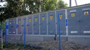 Electrical distribution substation behind blue grid fence
