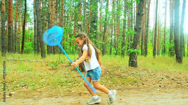 little girl with a butterfly net. a child runs with a butterfly net in the park through a nature forest in summer catches insects. happy family kid dream concept. baby play in the summer fun run