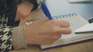 A woman writing in her spiral notebook - Free Stock Video