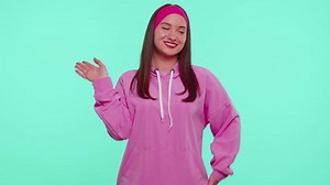 Girl teenager smiling friendly at camera and waving hands gesturing hello, hi or goodbye, welcoming