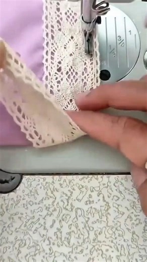 sewing several white lace pieces on a purple fabric using a professional manual sewing machine tool