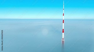 Aerial view of the Riga Radio and TV Tower in Riga, Latvia - the tallest tower in the European Union on a cloudy winter morning. Tower partly covered in thick clouds.